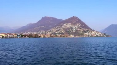 Monte Bre, Monte Boglia, Monte Sighignola ve Monte San Salvatore manzaralı açık mavi Lugano Gölü arkasında güneşli bir günde, Lugano, İsviçre
