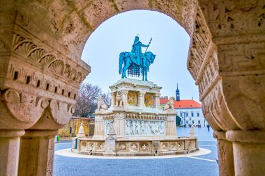 The view on St Stephen statue on Holy Trinity Square through the arch of stone gallery of Fisherman's Bastion, Budapset, Hungary clipart
