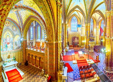 BUDAPEST, HUNGARY - 28 Şubat 2022: 21 Şubat 'ta Budapeşte, Macaristan' da Matthias Kilisesi 'nin iç kısımlarında kaburga kasaları, sütunlar, vitray pencereler ve ahşap mobilyalar ile panoramik manzara