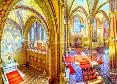 BUDAPEST, HUNGARY - FEBRUARY 28, 2022: Panoramic view on the interior of Matthias Church with carved rib-vaulted ceiling, columns, stained-glass windows and wooden furniture, on February 21 in Budapest, Hungary clipart