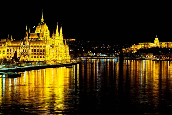 stock image Bright illuminated Parliament building on bank of Danube River, Budapest, Hungary