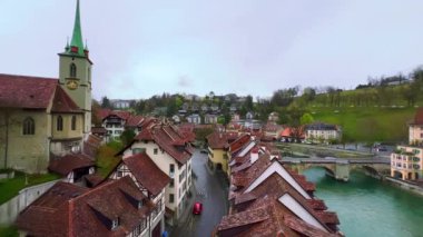 Aare Nehri 'nin karşısındaki Untertor Köprüsü ile Panorama, Nydeggkirche kilisesi eski kırmızı kiremit çatıları ve karşı kıyıdaki Felsenburg kulesi, Bern, İsviçre