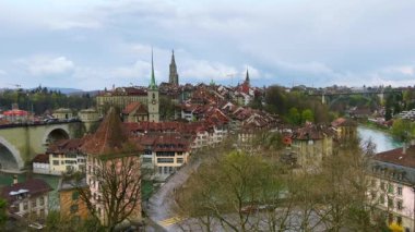 Önünde bereketli ağaçlar ve Aare nehri olan Aargauerstalden 'den Bern' ün eski kiremit çatıları ve yüksek kuleleri, İsviçre
