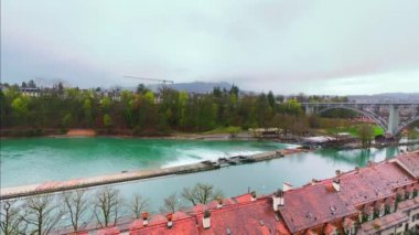 Aare Nehri 'nin Panorama' sı ile Mattenschleife Weir ve Kirchenfeldbrucke Köprüsü arasında Bern 'in aşağı kasabasının tarihi kırmızı çatıları arkasında, İsviçre