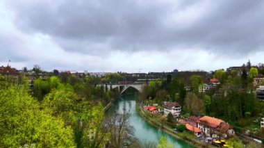 Lorraine Köprüsü ve Lorraine demiryolu Aare Nehri 'nin karşısında, Bern, İsviçre' deki yemyeşil parklarla çevrili.