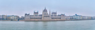 Macaristan 'ın Budapeşte şehrinde sabah sisli bir havada Tuna Nehri ve Pest tarafında Parlamento binasının panoraması