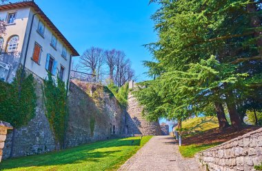 San Vigilio Şatosu, Bergamo, İtalya 'nın ortaçağ taş surları boyunca parkta yürü.