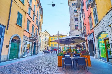 Orta Çağ San Leonardo Kilisesi, Bergamo, İtalya 'nın önündeki Via Sant' Alessandro 'daki renkli evler ve açık hava yemekleri.