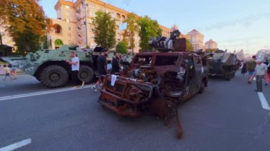 İnsanlar Ukrayna 'nın Bağımsızlık Günü, Kreshhatyk Bulvarı, Kyiv, Ukrayna' nın bağımsızlığı nedeniyle imha edilmiş Rus askeri teçhizatı sergisinde bombalanmış ve yakılmış çok amaçlı Tigr piyade aracını keşfediyorlar.