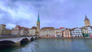 Limmatquai Irmağı 'ndan gelen zaman çizelgesi Lindenhof mahallesi, Munster Köprüsü, Fraumunster ve St. Peterskirche Kiliseleri, Zürih, İsviçre üzerindeki bulutlu gökyüzü manzaralı.