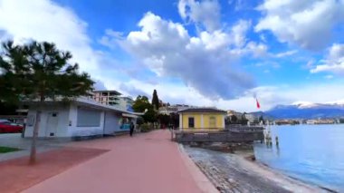 Parco Belvedere gölünde uzun ağaçlar, kırmızı banklar ve Lugano Gölü, Monte Bre, Monte Boglia ve Lugano Prealps, Lugano, Ticino, İsviçre