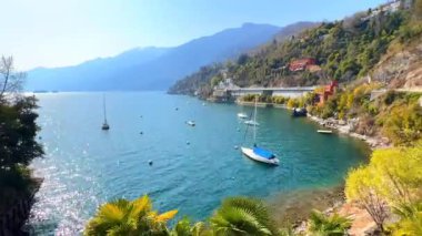 Zaman çizelgesi Maggiore Gölü 'nün etrafında demirli tekneler, yatlar ve arka planda sisli Alpler, Ascona, Ticino, İsviçre