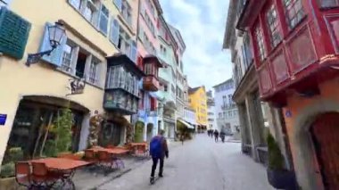 ZURICH, SWitzERLAND - 3 Nisan 2022: Augustinergasse Caddesi 'nin renkli evleri, Widdergasse Caddesi, Rennweg ve St. Peterskirche' de 3 Nisan 'da Zürih' te bulunan tarihi Lindenhof mahallesi