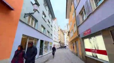 ZURICH, SWitzERLAND - 3 APRIL 2022: Eski kasaba Oberdorfstrasse 'den Grossmunster Kilisesi' ne ve izleme terasına yürür, Limmatquai setini, Limmat Nehri 'ni ve Zürih ufuk çizgisini Fraumunster ve St. Peterskirche kuleleriyle gözlemler.