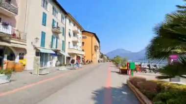 Lugano Gölü 'nün Riva dal Garavell seti boyunca tarihi binalar, kafeler, dükkanlar ve Alpler, Morcote, İsviçre manzaralı bir yürüyüş.