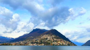 Monte Bre ve Lugano Gölü, Lugano, Ticino, İsviçre üzerinde hızla akan beyaz tüylü bulutların zamanı.