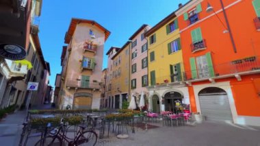 Torri caddesindeki eski, dar Vicolo 'nun panoraması renkli evler, küçük açık kafeler, dükkanlar ve ortaçağ Pallata Kulesi, Brescia, İtalya