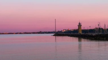 The bright purple dusk on Lake Garda with a view on the old stone lighthouse at the entry of the Porto Vecchio (Old Port), Desenzano del Garda, Italy