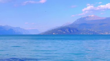 Sirmione, Lombardy, İtalya 'daki Garda Gölü' nden gelen puslu dağ manzarasının tadını çıkar.