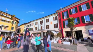 Piazza Giosue Carducci, Sirmione, İtalya 'daki tipik İtalyan mimari ve açık hava restoranlarının panoramik görüntüsü