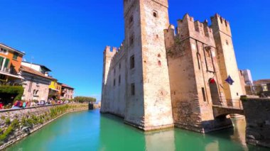 Sirmione 'nin ana tarihi simgesi, Via Dante caddesindeki hendek ve renkli evlere sahip Castello Scaligero, İtalya Sirmione' dir.