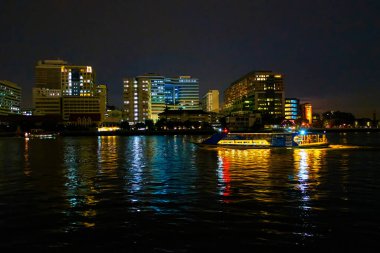 Chao Phraya Nehri 'nin gece manzarası ve Bangkok, Tayland kıyıları boyunca uzanan binalar.
