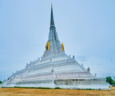 Visit ancient Wat Phukhao Thong temple with its high white Chedi, Ayutthaya, Thailand clipart