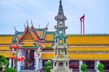 The courtyard of Wat Suthat Temple with covered gallery, slender pillar-lantern and Giant Swings on background, Bangkok, Thailand clipart