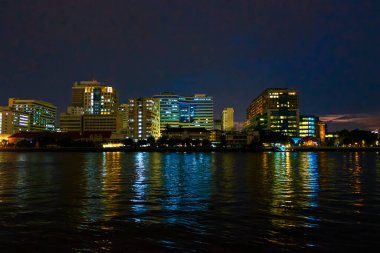 Chao Phraya Nehri 'nin gece manzarası ve Bangkok, Tayland kıyıları boyunca uzanan binalar.