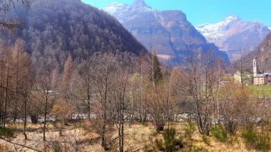 İlkbaharda kurak ormanın manzarası Valle Verzasca ve arka planda ortaçağ Sonogno köyü, Ticino, İsviçre