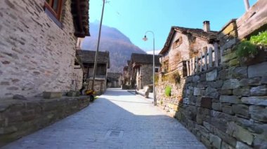 Lepontine Alpleri, Sonogno, Frasco, Valle Verzasca, İsviçre ile çevrili geleneksel evlerle dolu taştan caddede yürü