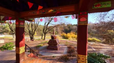 Budist bayraklarıyla Tibet Bahçesi 'nde güneşli bir sonbahar öğle vakti, meditasyon için çardak ve arka planda Chorten, Ukrayna' daki Kyiv Botanik Bahçesi