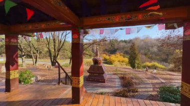 Tibet Bahçesi, Kiev Botanik Bahçesi, Ukrayna meditasyonu için Gazebo 'nun kereste sütunlarının arkasında görülen oyulmuş taş kordonu.