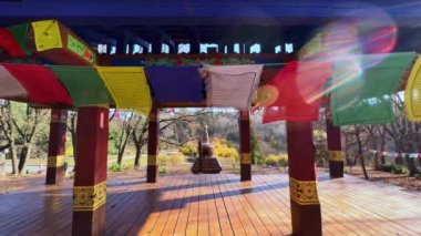 Siyahi Budist dua bayrağı Ukrayna 'daki Kiev Botanik Bahçesi Tibet Bahçesi meditasyonu için çardağın önünde.