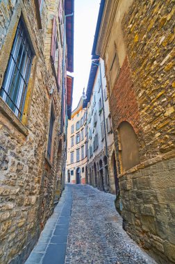 İtalya 'nın Bergamo kentindeki dar kavisli Via Alla Rocca' nın her iki tarafındaki uzun taş evler.
