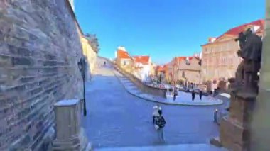 PRAGUE, CZECH REPUBLIC - 12 Mart 2022: Mala Strana distirct şehir yürüyüşü, kıvrımlı yamaçlı Radnicki Schody caddesi, dar tarihi Nerudova sokağı, St Nicholas Kilisesi ile Lesser Quarter Meydanı ve Prag tramvaları ile 12 Mart 'ta