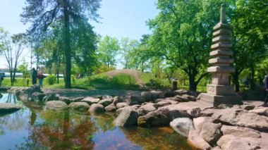 KYIV, UKRAINE - 11 Mayıs 2021: Kyoto Park 'ta Japon çok katlı Budist Pagoda ile küçük göletin panoraması, 11 Mayıs' ta Kyiv