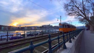 Retro sarı tramvay Tuna Nehri boyunca Buda Şatosu, Budapeşte, Macaristan 'a doğru ilerliyor.