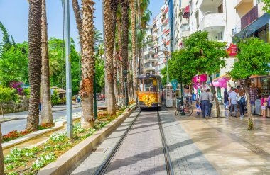 ANTALYA, TURKEY - 13 Mayıs 2017: Çiçek yatakları, palmiyeler ve turist pazarları, Barbaros, Antalya, Türkiye 'deki Atatürk Bulvarı' ndaki klasik tramvay
