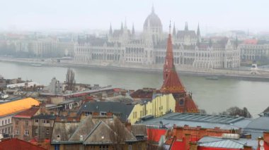 Tuna Nehri 'ne ve Gotik Parlamento' ya karşı Reform Kilisesi 'nin kırmızı çan kulesinin yüksek kulesi. Macaristan' ın Budapeşte kentindeki Balıkçı Kalesi 'nden gelen kış sisinde.
