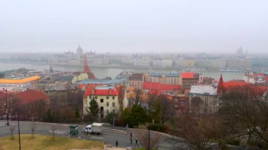 Budapeşte 'nin sisli kış manzarası tarihi Balıkçı Kalesi' nden, Buda, Tuna Nehri, Gotik Parlamento, Pest, Macaristan 'daki kiliseler ve köşkler kırmızı kiremit çatılarını gözlemliyor.