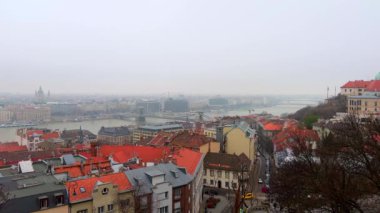 Buda Kalesi Tepesi, tepenin eteklerindeki eski şehir çatılarını, Tuna Nehri 'ni ve Macaristan' ın Budapeşte kentindeki Pest konutlarının sisli siluetini gözlemler.