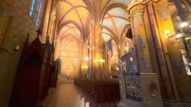 Matthias Kilisesi 'nin panoramik manzarası. Kaburga kemerli tavan, sütunlar, vitray pencereler ve ahşap mobilyalar, Budapeşte, Macaristan