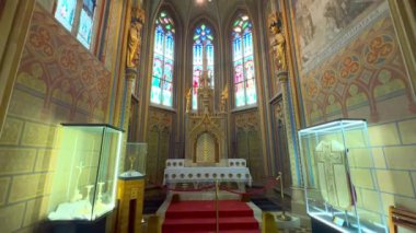 Süslü freskli duvarları, yontulmuş sunağı, vitraylı pencereleri ve Matthias Kilisesi, Budapeşte, Macaristan 'daki Aziz Stephen Şapeli' nde klasik avizeli kaburgalı tavanı olan bir panorama.