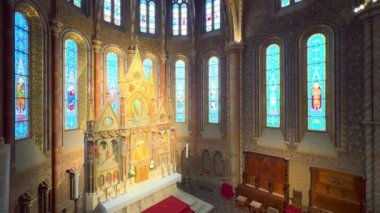 Matthias Kilisesi 'nin süslü dua salonu oyulmuş ana sunak, boyalı cam pencereler, freskli duvarlar ve kasayla, Budapeşte, Macaristan