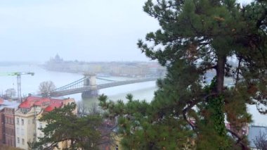Macaristan, Budapeşte 'deki Budapeşte Şatosu' nun yamacında, Tuna Nehri 'nin karşısındaki Szechenyi Zinciri Köprüsü' nün sisli manzarası.