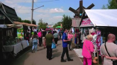 Ukrayna 'daki Ulusal Sorochynsky Panayırı' nın el sanatları tezgahları arasındaki dar sokakta yürü.