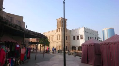 DUBAI, BAE - 1 Mart 2020: Dubai Heritage Village, Dubai Creek 'te 1 Mart' ta eski kerpiç evleri, el değirmeni avcıları, kafeler, hediyelik eşya dükkanları, market tezgahları ve manzaralı manzarayla yenilenen tarihi mahalle