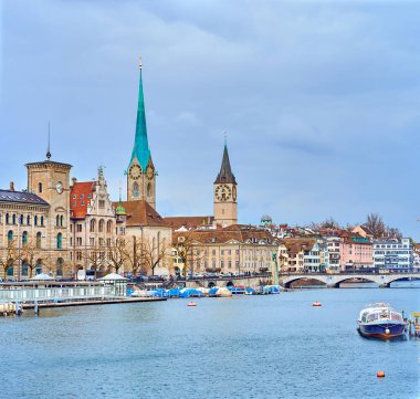 ZURICH, SWITZERLAND - APRIL 3, 2022: Zurich's iconic skyline boasts the Grossmunster and Fraumunster churches, set against the backdrop of the picturesque Limmat River panorama, on April 3 in Zurich, Switzerland clipart