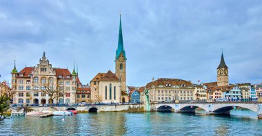 ZURICH, SWITZERLAND - APRIL 3, 2022: Zurich's iconic skyline boasts the Grossmunster and Fraumunster churches, set against the backdrop of the picturesque Limmat River panorama, on April 3 in Zurich, Switzerland clipart